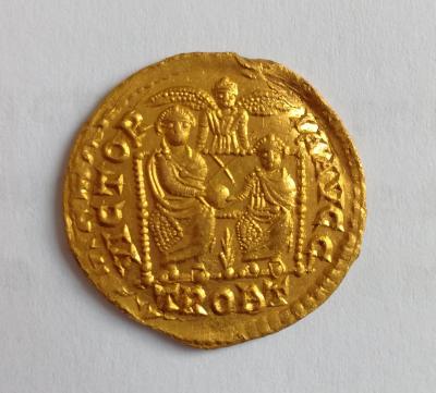 <p><strong><em>Back side</em></strong>, two seated emperors are holding a globe with the following Latin inscription VICTOR-IA AVGG // TROBT.</p>
